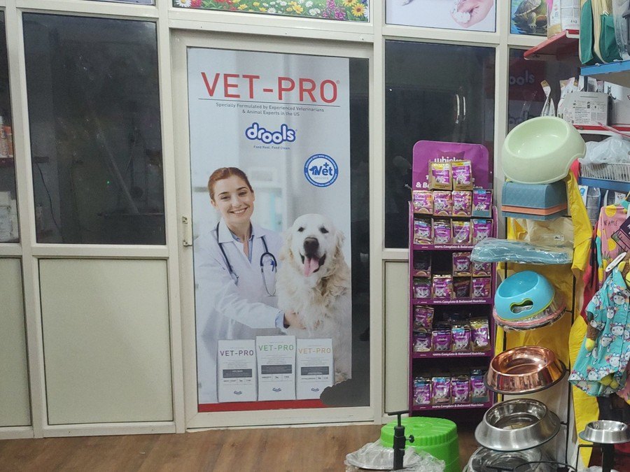 VET-PRO veterinary product shelf at Shree Swami Samarth Pets Shop, Ulhasnagar — pet supplements and medicines, with Dr. Sunil's consulting room behind